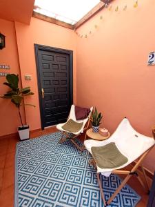two chairs and a table in a room with a door at Bellavista Basement in Costa Del Silencio