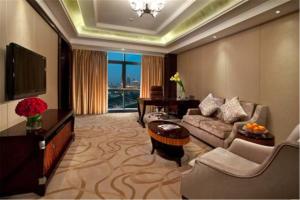 uma sala de estar com um sofá e uma televisão em Lv Shou Hotel em Xangai