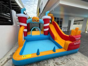 a inflatable bounce house in front of a house at TropINN LoDonHeartBeat 5LuxRoom CirPool BBQ & KTVFun in Bandar Penawar