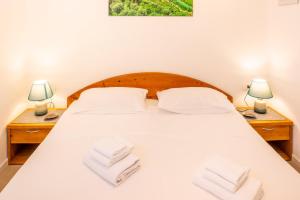 a bedroom with a white bed with towels on it at Panoramic Apartment SoleLago in Pai