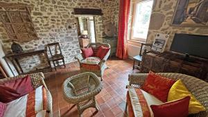 a living room with wicker chairs and a tv at Gîte Gîte du Chatelard 87 N°2 in Jabreilles-les-Bordes