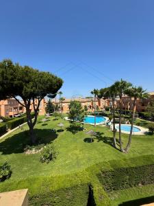 a view of a park with two pools and trees at Ático Jardín del Golf, Casa Alma in Chiclana de la Frontera