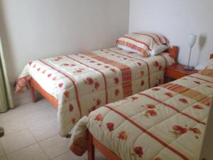 1 dormitorio con 2 camas y mesa en Pinares del Canelillo en Algarrobo, en Algarrobo