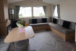 a living room with a couch and a table at Golden Sands 3-Bed Caravan Parking & Pet Friendly in Rhyl