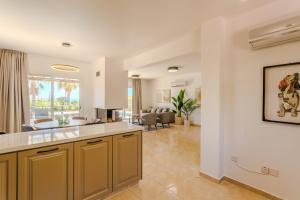 a kitchen and living room with a couch and a table at H&O Villa Arizona Gold Residence in Peyia +61 photos