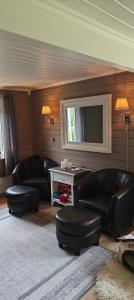 a living room with black leather furniture and a flat screen tv at Utsikten in Havningberg