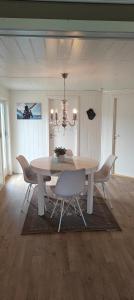 a dining room table with chairs and a chandelier at Utsikten in Havningberg +12 photos