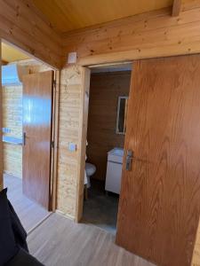 a door to a bathroom in a log cabin at Casa da Praia in Carvalhal +11 photos