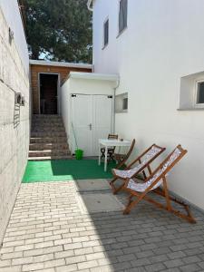 a patio with two chairs and a table and a building at Casa da Praia in Carvalhal