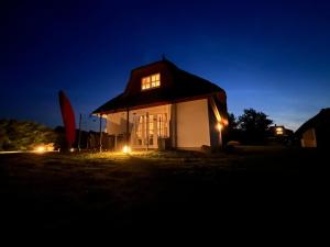 un piccolo edificio bianco con un tetto di notte di Krügers Auszeit a Zinnowitz