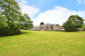 an open field with a large house and trees at The Annexe in Ammanford