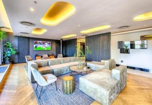 a living room with a couch and a tv at Executive Hotel Apartment at Oynx in Cape Town