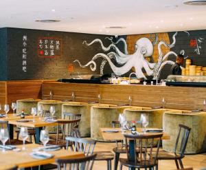 an empty restaurant with tables and an octopus painted on the wall at Executive Hotel Apartment at Oynx in Cape Town