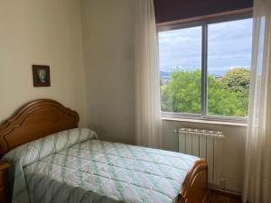 a bedroom with a bed and a large window at Piso Brisa de Barreiros in San Cosme de Barreiros