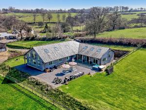 an aerial view of a large blue house in a field at 6 Bed in Oakford 60494 in North Molton