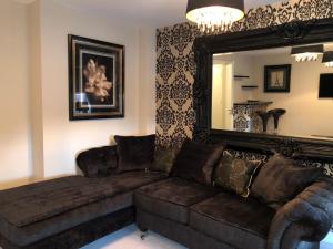 a living room with a brown couch and a mirror at 2-Bed Hillside House - Sleeps 4 Garden & Parking in Sheffield +2 photos