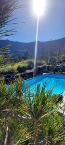 a blue swimming pool with the sun in the sky at Le torii in Cilaos
