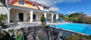 a house with a swimming pool in front of it at Le torii in Cilaos