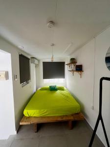 a bedroom with a bed with a green blanket at Casa Caia - simple rooms and studios at studenthouse in Willemstad