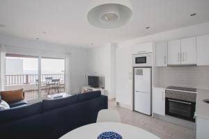 a living room with a blue couch and a kitchen at Blancazul Harbour View in Playa Blanca