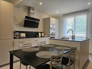 a kitchen with a black table and chairs in it at Maison Parenthèse Prestige Tours Centre in Tours