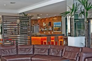 a living room with a brown couch and a bar at Hotel Meridional in Fortaleza