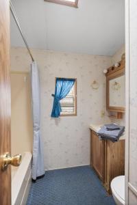 Un baño con bañera, lavabo y ventana. en Casa Villa Park, en Russell 1 foto más
