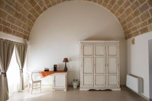 an archway in a room with a white cabinet and a table at grottedisileno in Castellaneta +28 photos