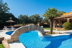 ein Pool mit einer Brücke und einer Palme in der Unterkunft Can Revell - Villa en el paraíso in Sant Llorenç des Cardassar + 4 Fotos