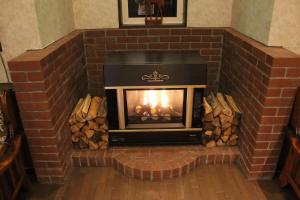 a brick fireplace with a fire in it at Appi Life is Beautiful in Hachimantai