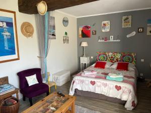 a bedroom with a bed and a chair and a table at Au repos du Lezard in Durtal +37 photos