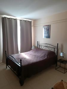 a bedroom with a bed and a window with curtains at Maison de vacances avec piscine Var in Callas