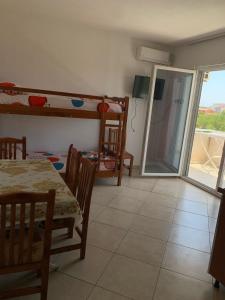a room with a table and a dining room with bunk beds at Hotel Armela in Velipojë