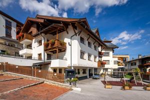 un grande edificio bianco con un tetto di legno di Apart-Hotel Aurora Fiss a Fiss