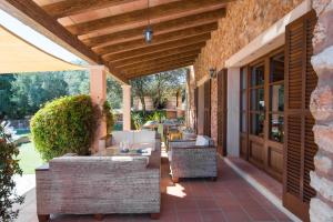 eine Außenterrasse mit Sofas und einer Holzdecke in der Unterkunft Can Revell - Villa en el paraíso in Sant Llorenç des Cardassar