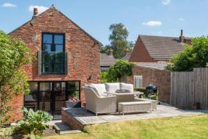 Marsh Mallow Cottage - Hot Tub Packages Available في لاوْبورو: فناء مع كرسيين وطاولة في ساحة