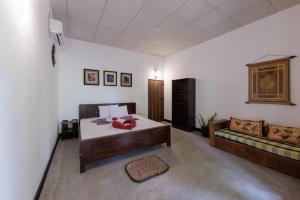 a bedroom with a bed and a couch in a room at BonaVista Beach Hotel in Arugam Bay