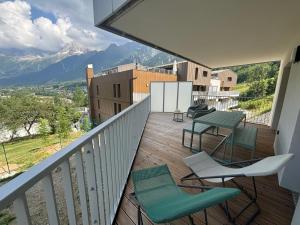 balcone con tavolo, sedie e montagne di Kayla du Mont-Blanc - Espace bien etre - Piscine a Les Houches