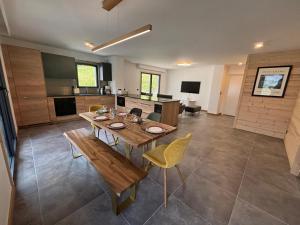 una grande cucina con un tavolo di legno e sedie gialle di Kayla du Mont-Blanc - Espace bien etre - Piscine a Les Houches