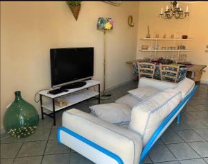 a living room with two couches and a flat screen tv at Nonna Maria B&B Home restaurant in La Marinella