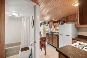 a kitchen with a white refrigerator and wooden cabinets at Vacation Home Rental PM C-06 in Russell