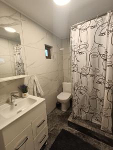 a bathroom with a toilet and a shower curtain at Colț de lavandă in Braşov
