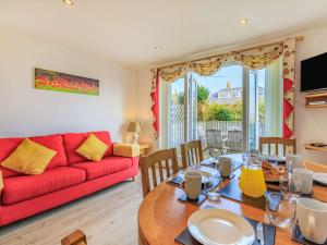 Una sala de estar con un sofá rojo y una mesa. en 3 Bed in Watchet 37336, en Watchet