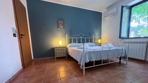 a bedroom with a bed and a blue wall at Masseria Brica Rossa in Thurio +24 photos