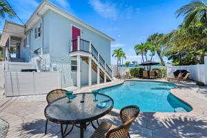 een patio met een tafel en stoelen naast een zwembad bij Casita Coconut – Pool, Grill, Pet Friendly, Located in the Heart of SK! in Siesta Key