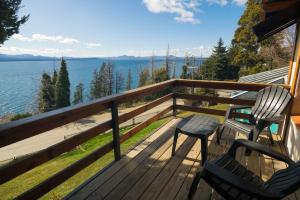 two chairs on a deck with a view of the water at Pailahue Cabañas Lodge in San Carlos de Bariloche