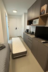 a small room with a bed and a kitchen at Confortável Apartamento próximo ao metrô Tucuruvi in Sao Paulo