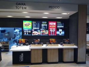 a food counter at a restaurant with signs on the wall at EcoLoft, melhor localização do centro, espaçoso e com ar in Juiz de Fora