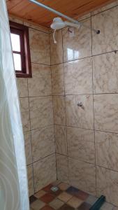 a bathroom with a tiled shower with a window at Vila Paolino in São Pedro da Serra