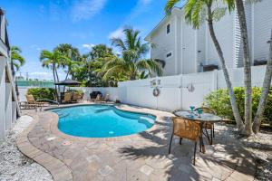 a pool with a table and chairs next to a building at Tidal Wave - In Siesta Key Village, Pet Friendly, Private Pool! in Siesta Key